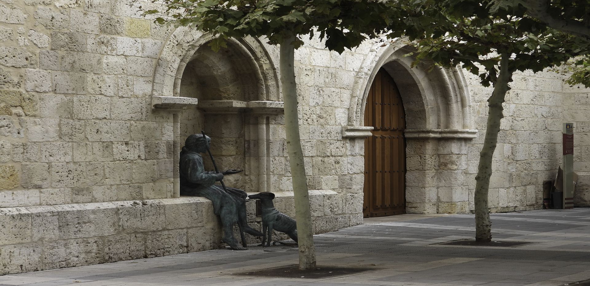 Leproso y su perro junto a la puerta de la Iglesia de San Lázaro